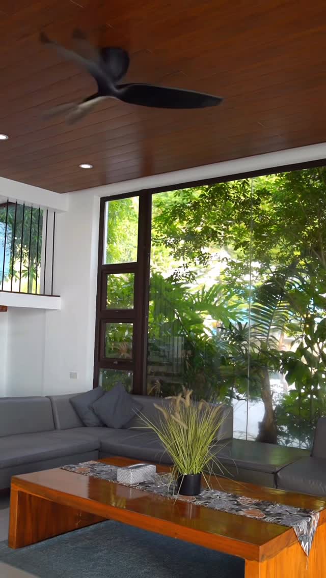 Lounge with glass wall and tropical garden view
